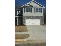 Two-story house with gray siding, stone accents, and a two-car garage at 347 Hopewell Branch Ct, Smithfield, NC 27577