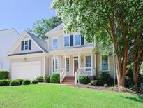 Charming two-story home featuring a welcoming front porch and lush green lawn at 102 Preston Pines Dr, Cary, NC 27513