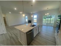 Bright, open kitchen features granite counters, stainless appliances, and a large island at 1528 Maelyn Way, Fuquay Varina, NC 27526