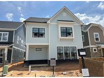 Charming new construction home with a light blue exterior and black framed windows at 2408 Adrift Road, Fuquay Varina, NC 27526