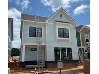 New two-story home with light blue siding, black windows, and a dark gray roof under a sunny sky at 2408 Adrift Road, Fuquay Varina, NC 27526