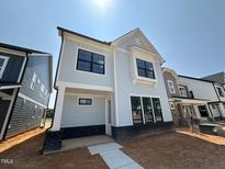 Charming two-story home featuring a light blue facade, black framed windows and modern architectural details at 2408 Adrift Road, Fuquay Varina, NC 27526