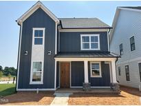Charming two-story home featuring dark siding, white trim, and a welcoming front porch at 2412 Adrift Road, Fuquay Varina, NC 27526