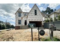 Two-story home under construction showing the initial framing and brickwork details against a partly cloudy sky at 3301 Dell Dr, Raleigh, NC 27609
