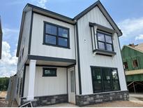 New two-story home boasts white siding, black trim, and stone accents at 2400 Adrift Rd, Fuquay Varina, NC 27526