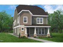 Charming two-story home with stone accents, inviting porch, and neutral colored siding at 2404 Adrift Rd, Fuquay Varina, NC 27526