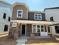 Charming two-story home with stone accents and a welcoming front porch, providing curb appeal at 2404 Adrift Rd, Fuquay Varina, NC 27526