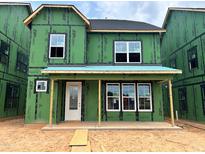 New construction home featuring green weather barrier, white windows, and covered front porch at 2404 Adrift Rd, Fuquay Varina, NC 27526