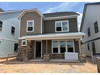 Charming two-story home featuring stone accents, two-tone siding, and a covered front porch at 2404 Adrift Rd, Fuquay Varina, NC 27526