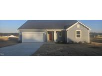Charming single-story home with gray siding, a two-car garage, and a well-manicured lawn at 159 Robert Howe Dr, Fuquay Varina, NC 27526