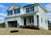 Beautiful two-story home featuring white siding, a two-car garage, and stone accents on the entryway at 315 Bishop Ln, Sanford, NC 27330