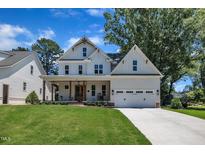 Charming two-story modern farmhouse with a two-car garage, covered porch, and lush lawn at 113 S Ennis St, Fuquay Varina, NC 27526
