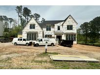 New two-story home under construction with black framed windows and spacious front yard at 7000 North Ridge Dr, Raleigh, NC 27615