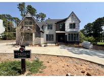 Two-story home with mixed exteriors of stone, stucco, and siding, and black window frames, under construction by Homestead Building Company at 7000 North Ridge Dr, Raleigh, NC 27615