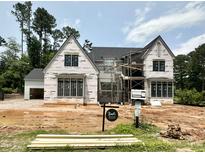Stunning new construction home featuring a modern design with black windows and a light-colored facade at 7000 North Ridge Dr, Raleigh, NC 27615