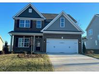 Charming two-story home featuring a brick facade, inviting front porch, and attached two car garage at 1932 Darrell Dr # 12, Graham, NC 27253