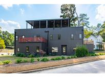 Modern three-story home with a black exterior, rooftop patio, and professionally landscaped front yard at 1511 Malta Ave, Raleigh, NC 27610
