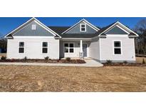New construction home with gray and white siding, stone accents, and landscaping at 16 Dark Night Ln, Zebulon, NC 27597