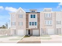 Modern three-story townhome with brick and siding, featuring an attached garage and well-maintained landscaping at 2038 Fishamble St, Fuquay Varina, NC 27526