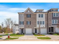 Modern townhouse with brick and gray siding, featuring a two-car garage and manicured lawn at 2042 Fishamble St, Fuquay Varina, NC 27526