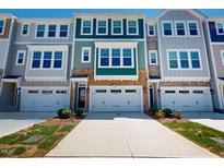 Townhome exterior showcasing modern architecture, stone accents, and attached garages at 2337 Bay Minette Sta # 553, Apex, NC 27502