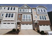 Three-story townhome with brick and siding, two-car garage, and landscaping at 2370 Bay Minette Sta # 697, Apex, NC 27502