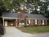 Charming single-story brick home with a well-manicured lawn and mature trees at 301 Briarcliff Dr, Dunn, NC 28334