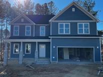 Two-story house with blue siding, stone accents, and a two-car garage at 448 Little River Dr, Zebulon, NC 27597