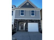 Two-story townhome with gray siding, stone accents, and a two-car garage at 16 Clementine Street St # 208, Angier, NC 27501