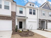Charming townhome showcasing a light and airy exterior with a one-car garage and manicured front yard at 18 Clementine Street St # 207, Angier, NC 27501