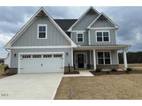 Charming two-story home with gray siding, white trim, a two-car garage, and a well-manicured lawn at 443 Ravensworth Dr, Garner, NC 27529