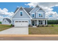 Charming two-story home featuring a light blue exterior, white trim, and an attached two-car garage at 443 Ravensworth Dr, Garner, NC 27529