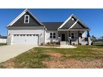 Charming single-story home features a two-car garage and inviting front porch at 101 Seahawk Way, Zebulon, NC 27597