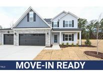 Move-in ready two-story home with gray siding, stone accents, and a two-car garage at 158 Abingdon Farms Dr, Selma, NC 27576