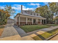 Stunning two-story home boasts a metal roof, brick accents, inviting front porch, and detached garage at 505 S Magnolia Ave, Dunn, NC 28334