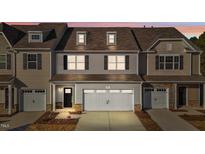Tan three-story townhome with white garage doors and landscaping at 806 Pryor St # 50, Mebane, NC 27302