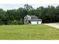 Two-story home with large front yard, attached two-car garage, and craftsman-style architectural details at 236 Alden Way, Angier, NC 27501