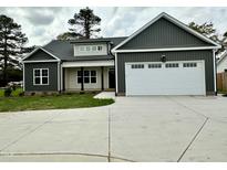 Charming single-Gathering home featuring a two-car garage, dark gray exterior, and well-manicured lawn at 6965 Us-401, Fuquay Varina, NC 27526