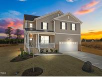 Two-story house with a neutral color scheme, a two-car garage, and a landscaped yard at 15 Diamond Creek Dr, Zebulon, NC 27597