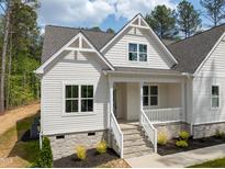 Charming home with stone accents, white siding, landscaped yard, and a welcoming front porch with stone steps at 205 Purslane Dr, Franklinton, NC 27525