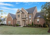 Beautiful brick and stone home with well-manicured lawn, colorful flowerbeds, and a welcoming entrance at 2028 Pleasant Forest Way, Wake Forest, NC 27587