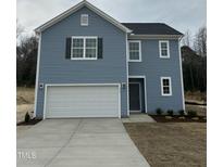 Charming two-story home with blue siding, white garage door, and manicured lawn showcasing classic design at 259 Johnson Ridge Way, Four Oaks, NC 27524