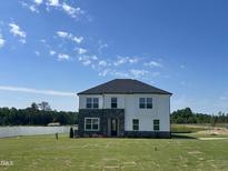 Beautiful two-story home with stone and white siding accents and a well-manicured lawn at 225 Bering Cir, Angier, NC 27501