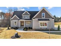 Charming home featuring a gray exterior, complemented by well-maintained landscaping at 25 Firefly Ln, Youngsville, NC 27596
