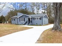 Newly renovated gray brick ranch home with modern gray accents and a long driveway at 4713 Zebulon Rd, Zebulon, NC 27597