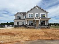 Two-story home with stone accents and large windows on a large lot at 111 Demascus Way # 021, Four Oaks, NC 27524