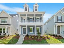 Charming two-story home featuring a double front porch, grey siding, and meticulously landscaped front yard at 9216 Leaning Post Rd # 447, Wake Forest, NC 27587