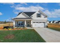 Two-story house with gray siding, stone accents, and a two-car garage at 207 Wildwood Ln, Graham, NC 27253