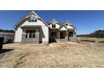 New construction home featuring a stylish exterior with stone accents and a charming craftsman design at 120 Firefly Ln, Louisburg, NC 27549