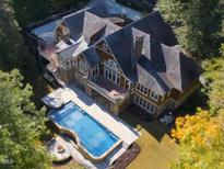 Stunning aerial view of the large home, showcasing the pool, hot tub, and surrounding greenery at 3105 Cone Manor Ln, Raleigh, NC 27613